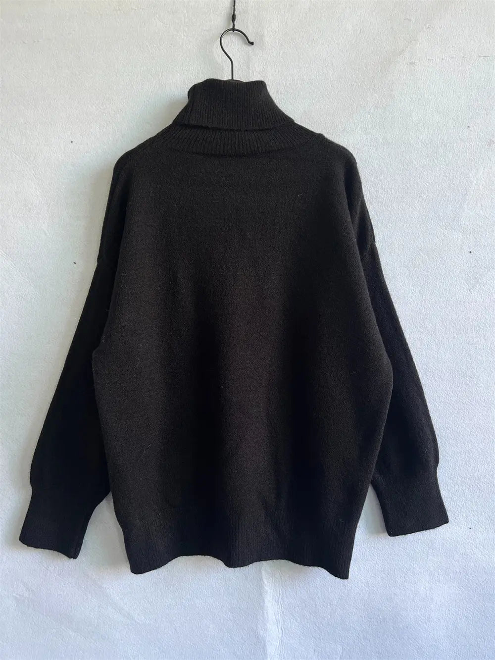Turtleneck long-sleeve sweater in dark color, ribbed collar and cuffs, relaxed fit.