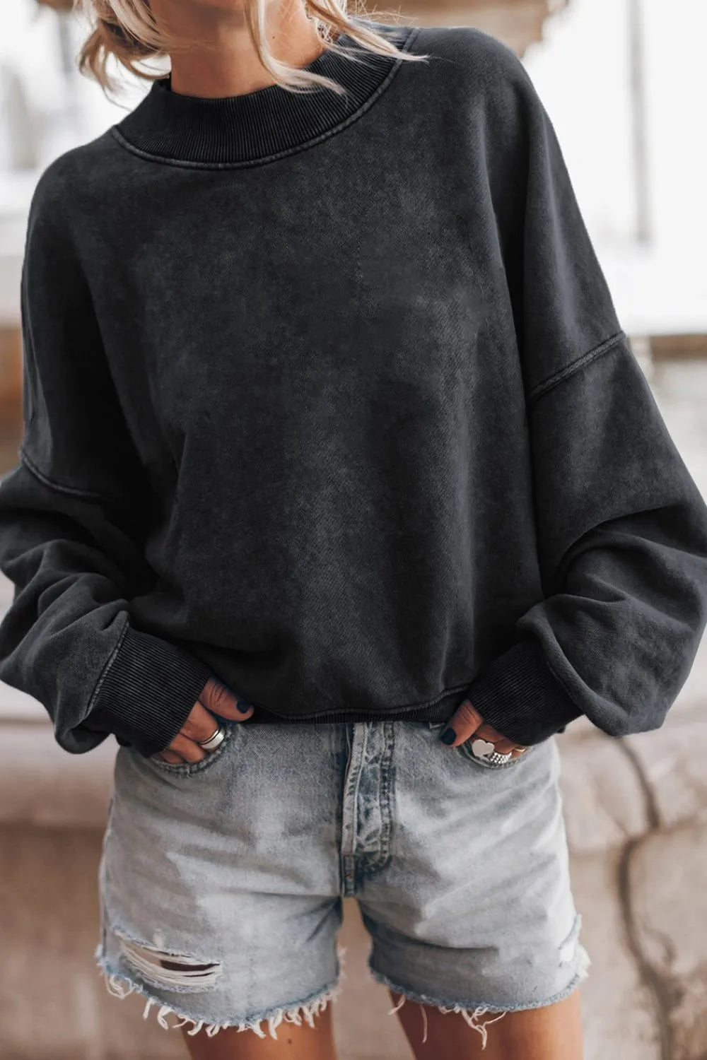 Black mock neck dropped-shoulder sweatshirt with long sleeves and ribbed hem
