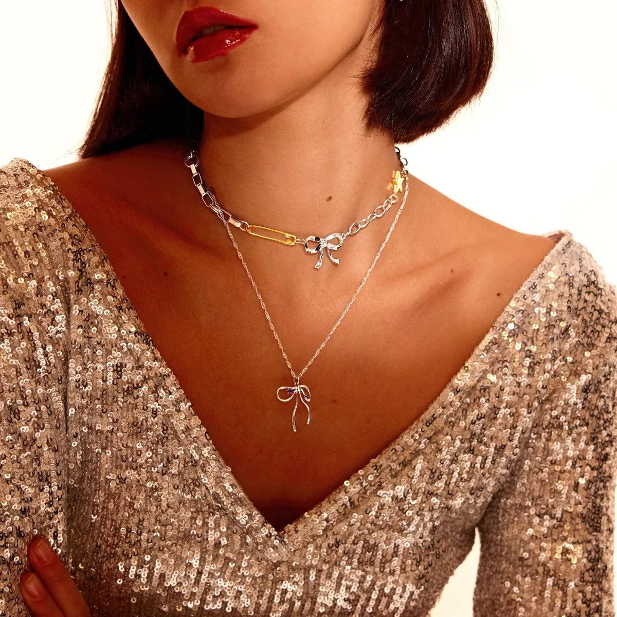 Two-tone star bow necklace with ribbon bow charm and gold accents on silver chain
