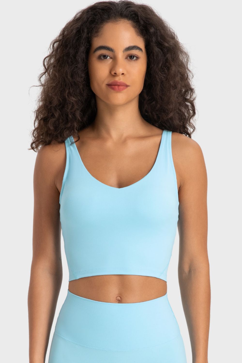Deep V-neck crop sports bra with racerback, light blue color, front view.