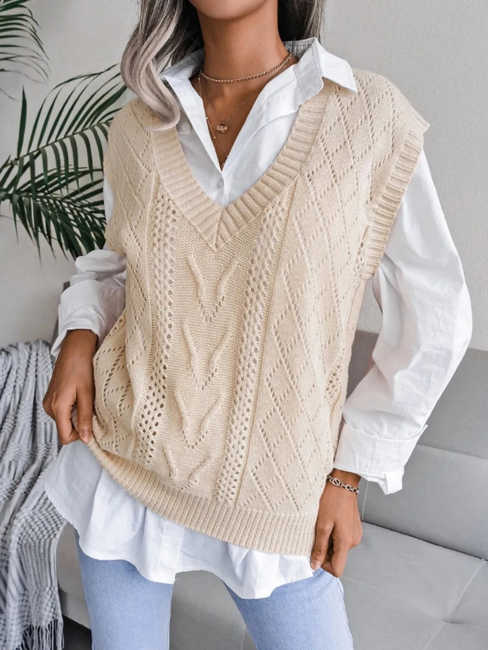 Cream openwork V-neck sweater vest, sleeveless knit with vertical textured V pattern.