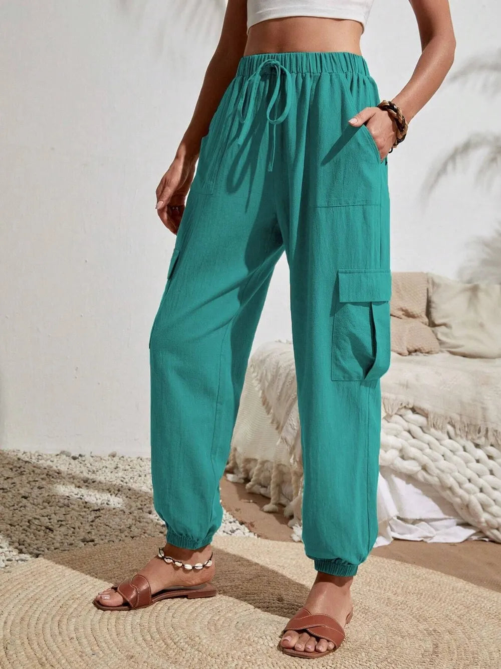 Drawstring joggers with cargo pockets in teal green, drawstring waist, elastic cuffs
