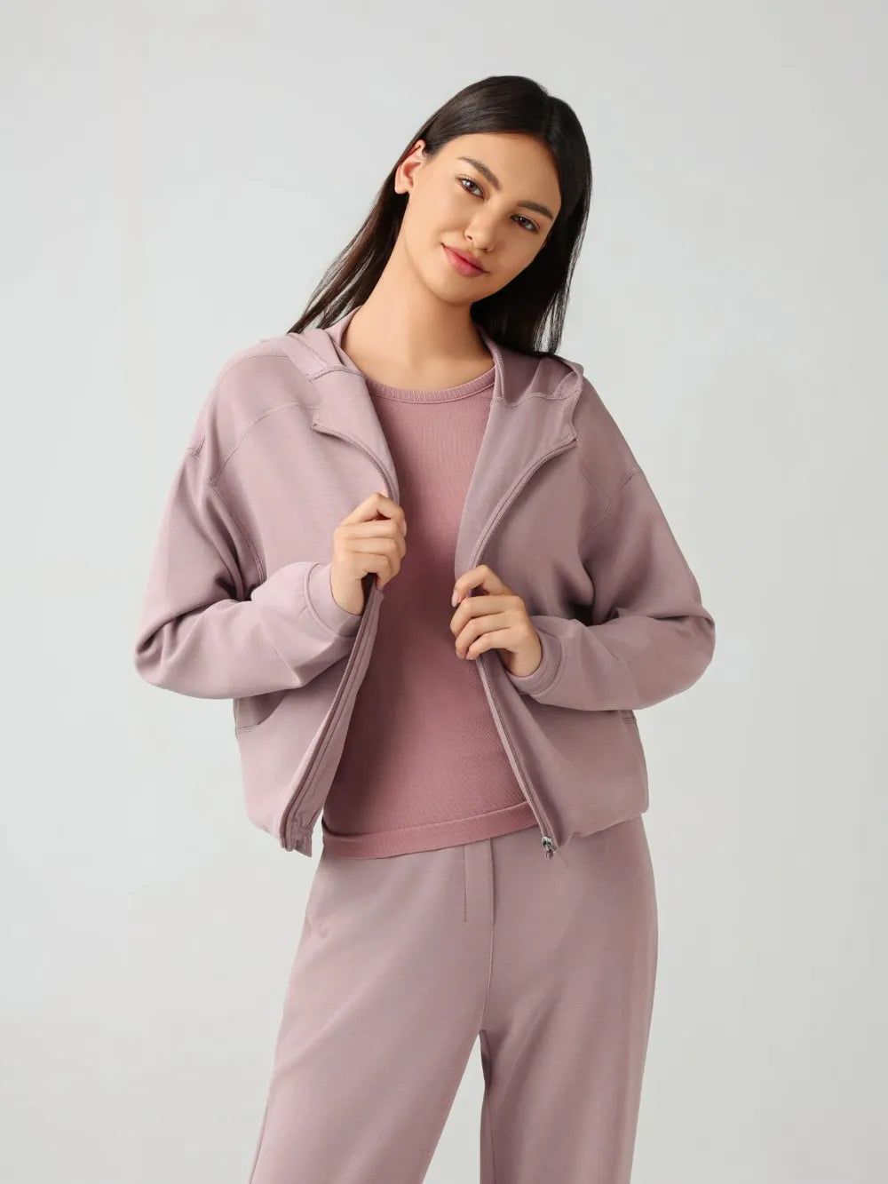 Dusty pink zip-up active hoodie with hood, front zipper, and drawcord-style neckline trim