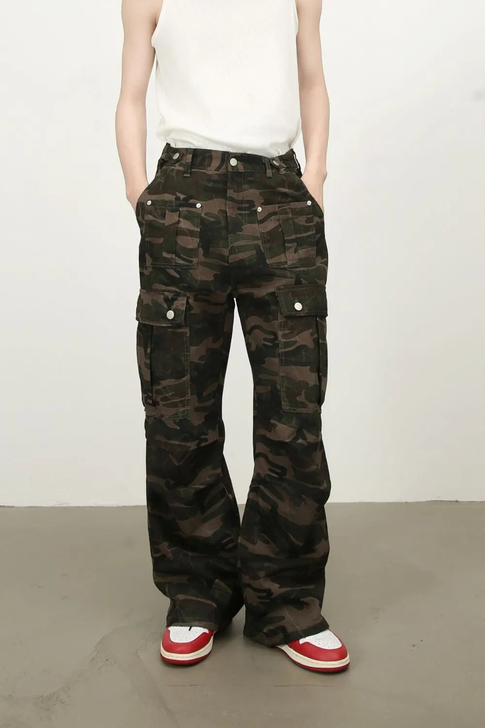 Men's green camouflage cargo jeans with multiple flap pockets and button waist