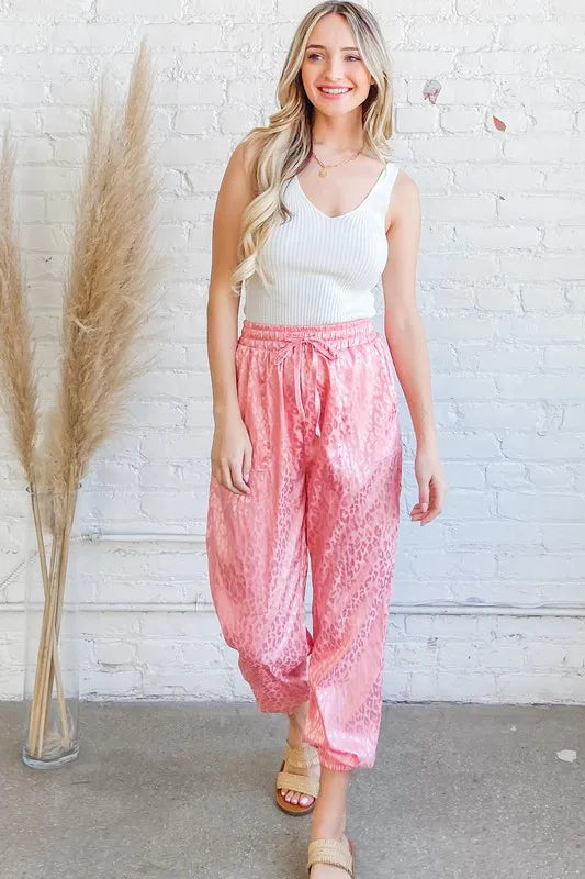 Pink satin leopard print joggers with drawstring waist and tapered cuffs
