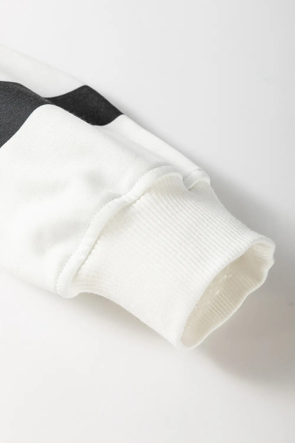 Cream knit sleeve cuff and hem with black stripe