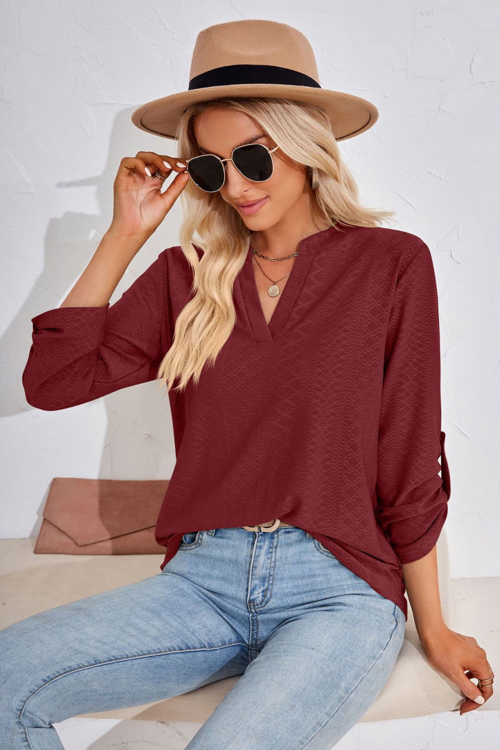 Burgundy V-neck blouse with roll-tap sleeves and textured fabric