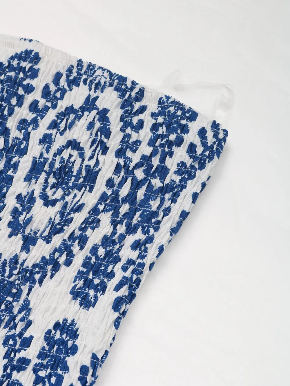 Blue and white smocked fabric close-up with gathered, textured ruching