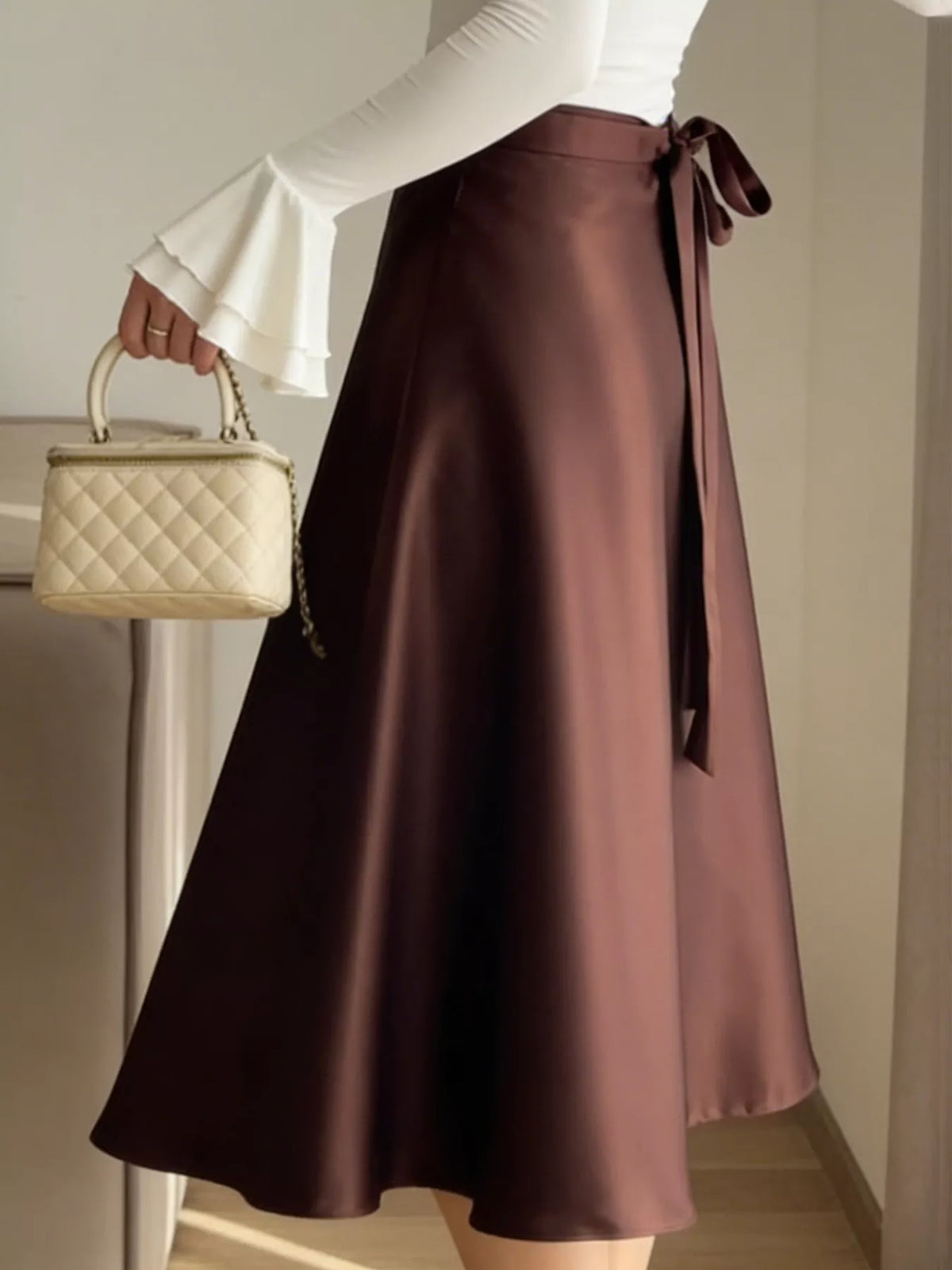 Burgundy satin A-line midi skirt with side drape and bow detail