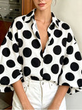 White polka dot button-front shirt with puff sleeves and pointed collar