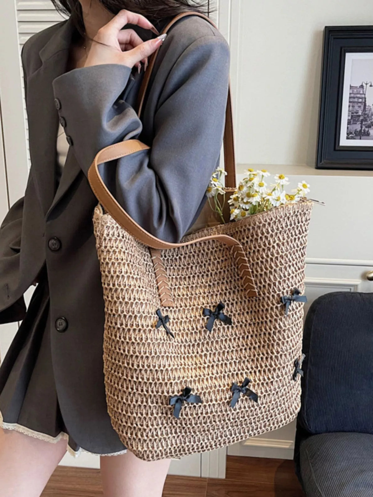Woven straw tote bag with caramel handles and scattered bow applique detail