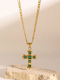 Gold-tone cross pendant necklace with green square stones on a fine chain