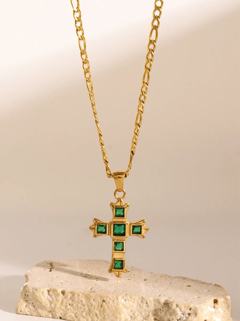 Gold-tone cross pendant necklace with green square stones on a fine chain
