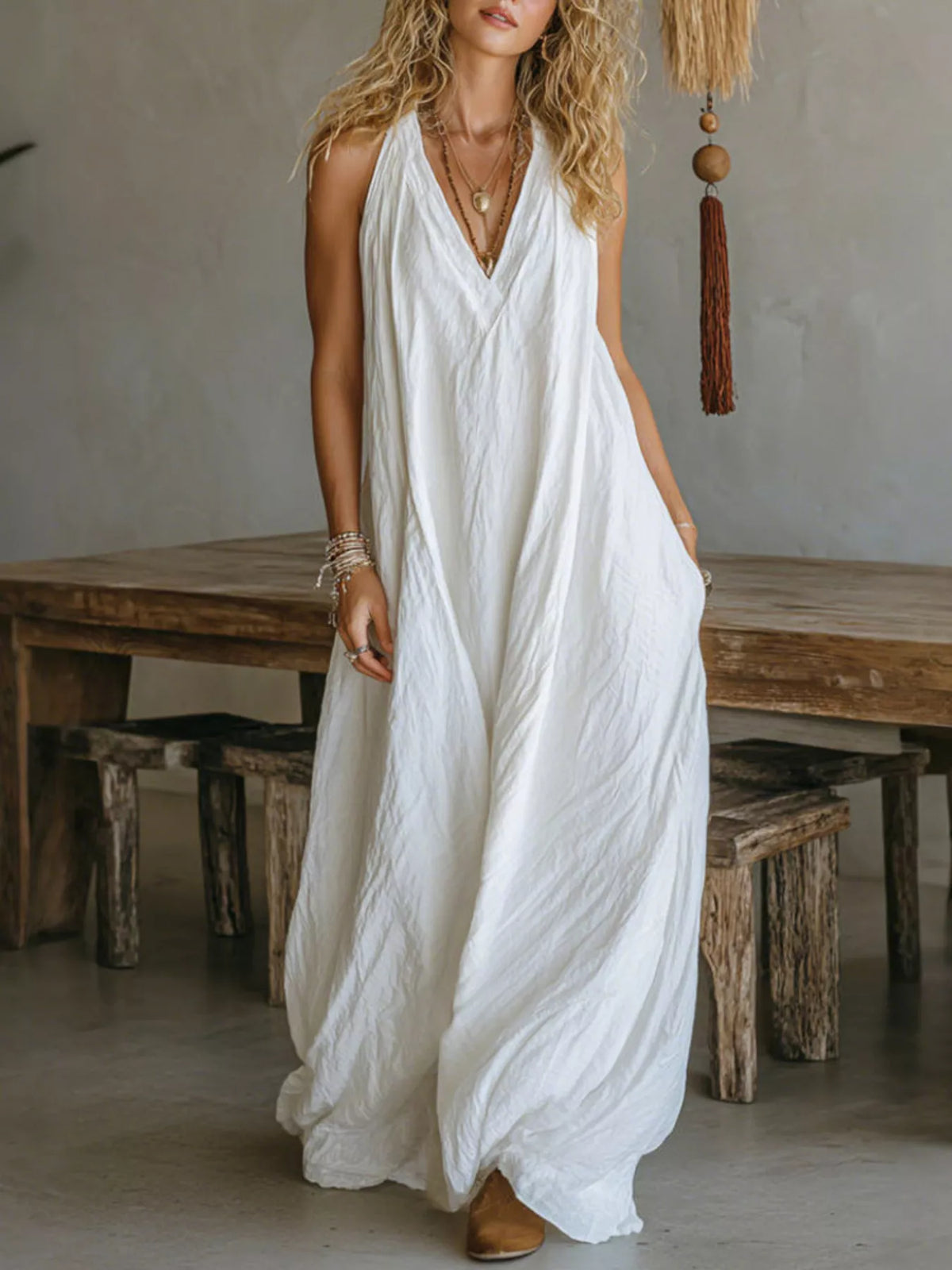 White sleeveless V-neck flowy maxi dress with loose, gathered skirt