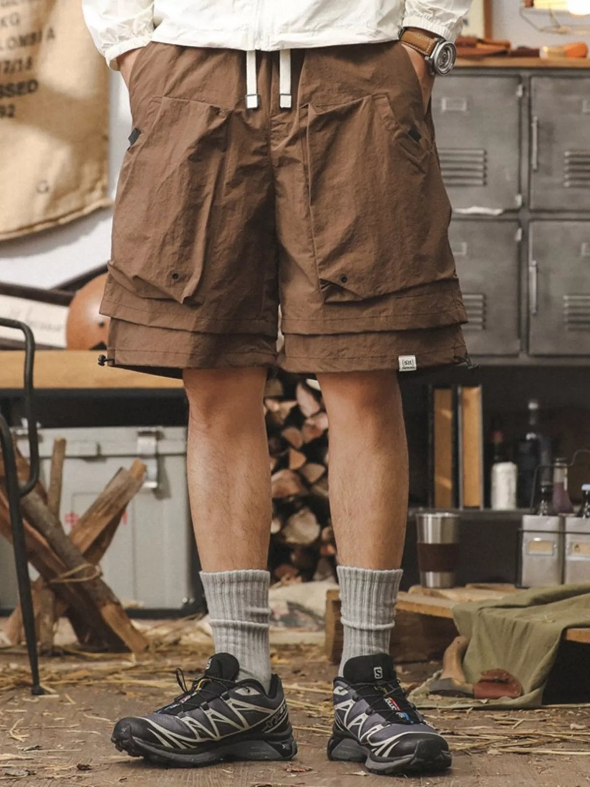 Brown men's cargo shorts with drawstring waist and multiple utility pockets