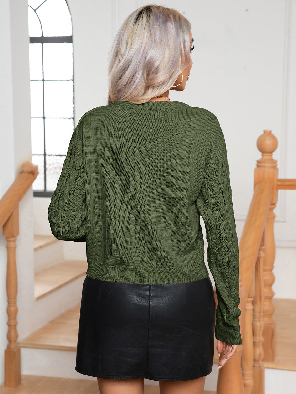 Dark green cable-knit round-neck sweater, back view, long sleeves and ribbed hem and cuffs