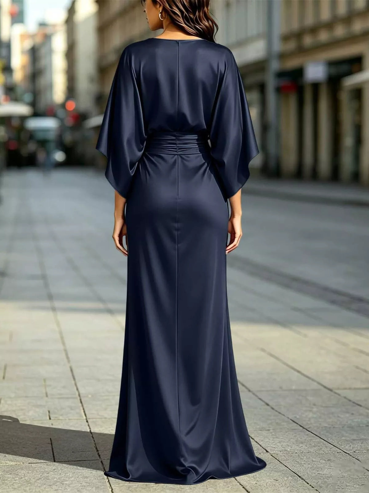 Back view of ruched waist maxi dress with draped dolman sleeves and front slit in navy blue