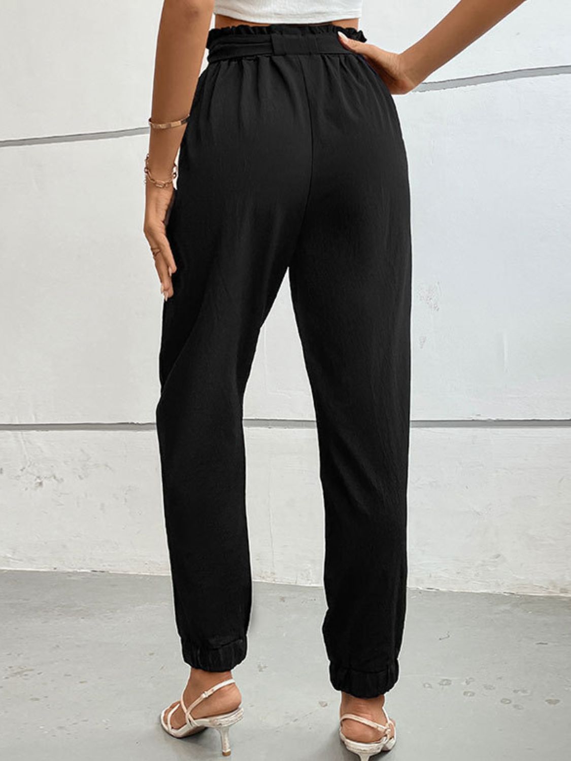 Black high-waist long pants with elastic waistband, gathered cuffs, and bow tie