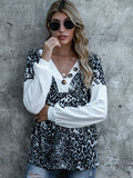 Leopard print button V-neck top with white sleeves and gold-tone decorative buttons