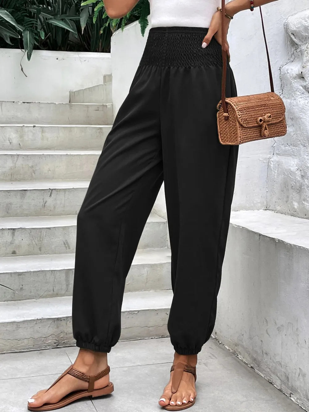 Black smocked high-rise joggers with side pockets and gathered ankle cuffs