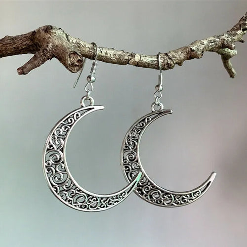 Silver-tone crescent moon earrings with ornate cutout detailing, dangle hooks