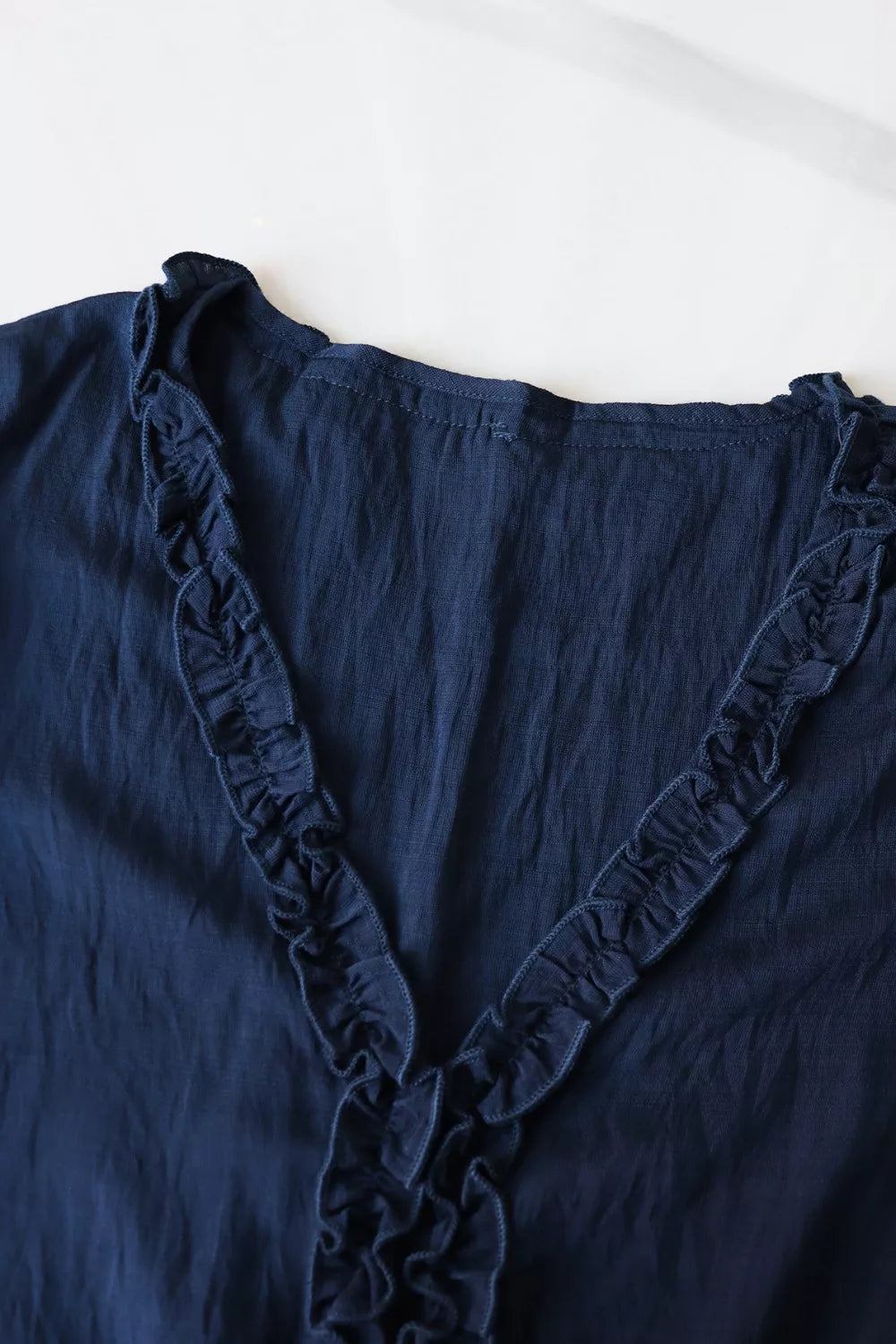 Ruffle Hem Tie Neck Blouse in navy blue with ruffle trim and buttoned front
