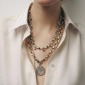 Layered pendant necklace set with round medallion and horn charm, gold-tone chains