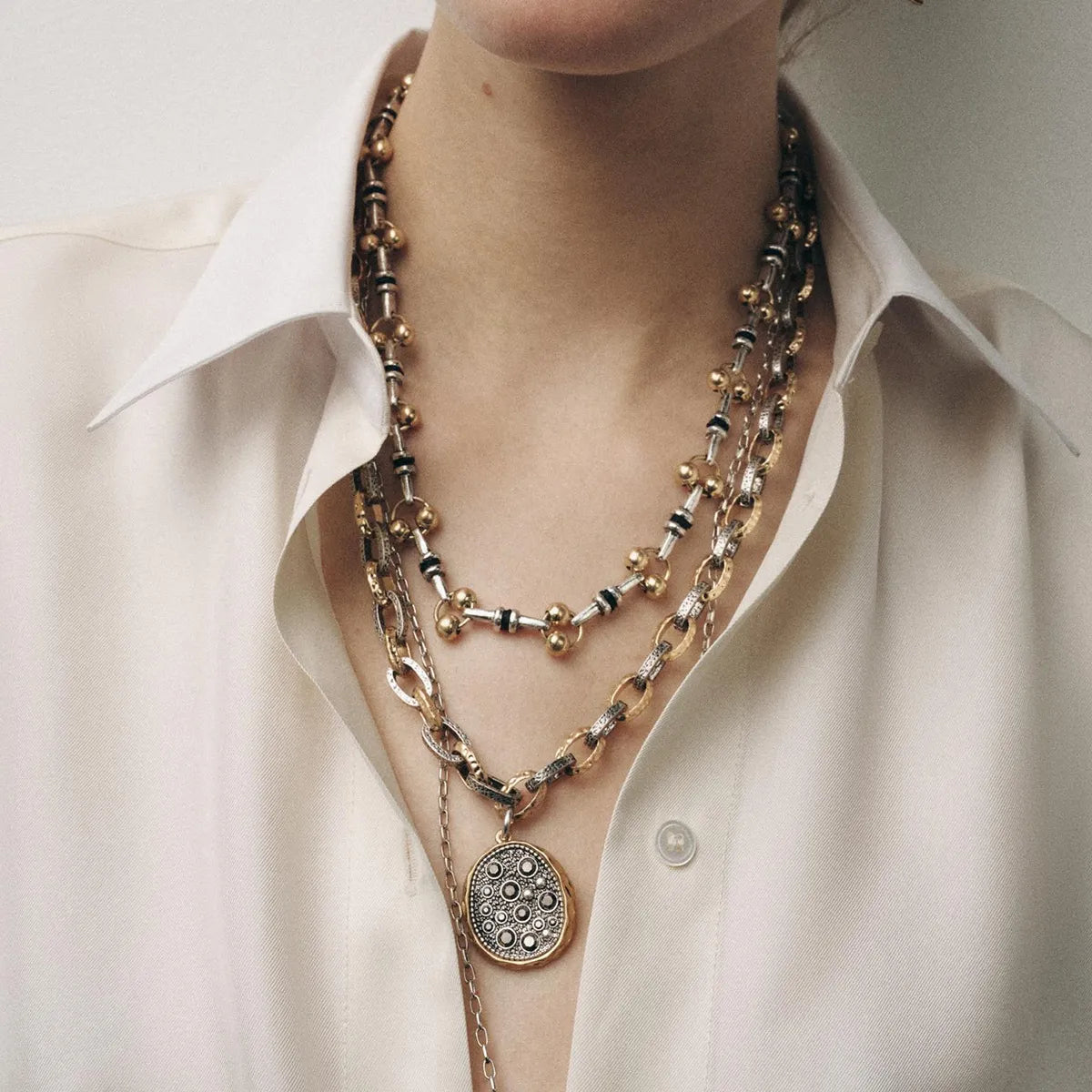 Layered pendant necklace set with round medallion and horn charm, gold-tone chains