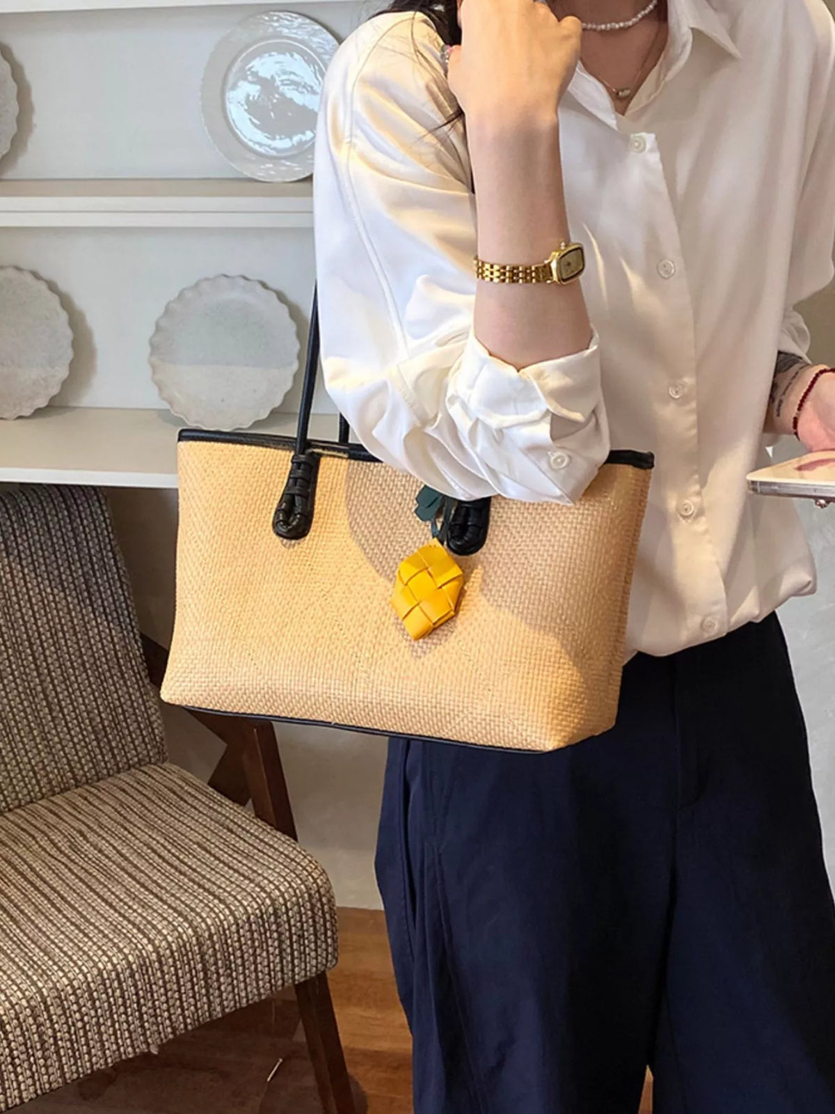 Beige leather shoulder bag with brown top handles and yellow charm detail