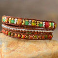 Natural stone woven bracelet with orange, green and gold bead details