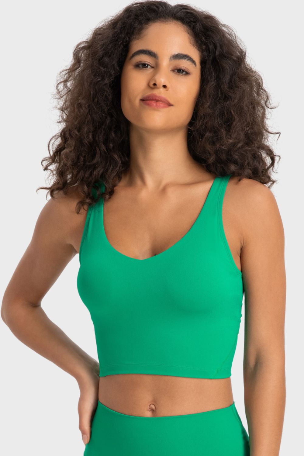 Deep V-neck crop sports bra with racerback, bright green color, front view.