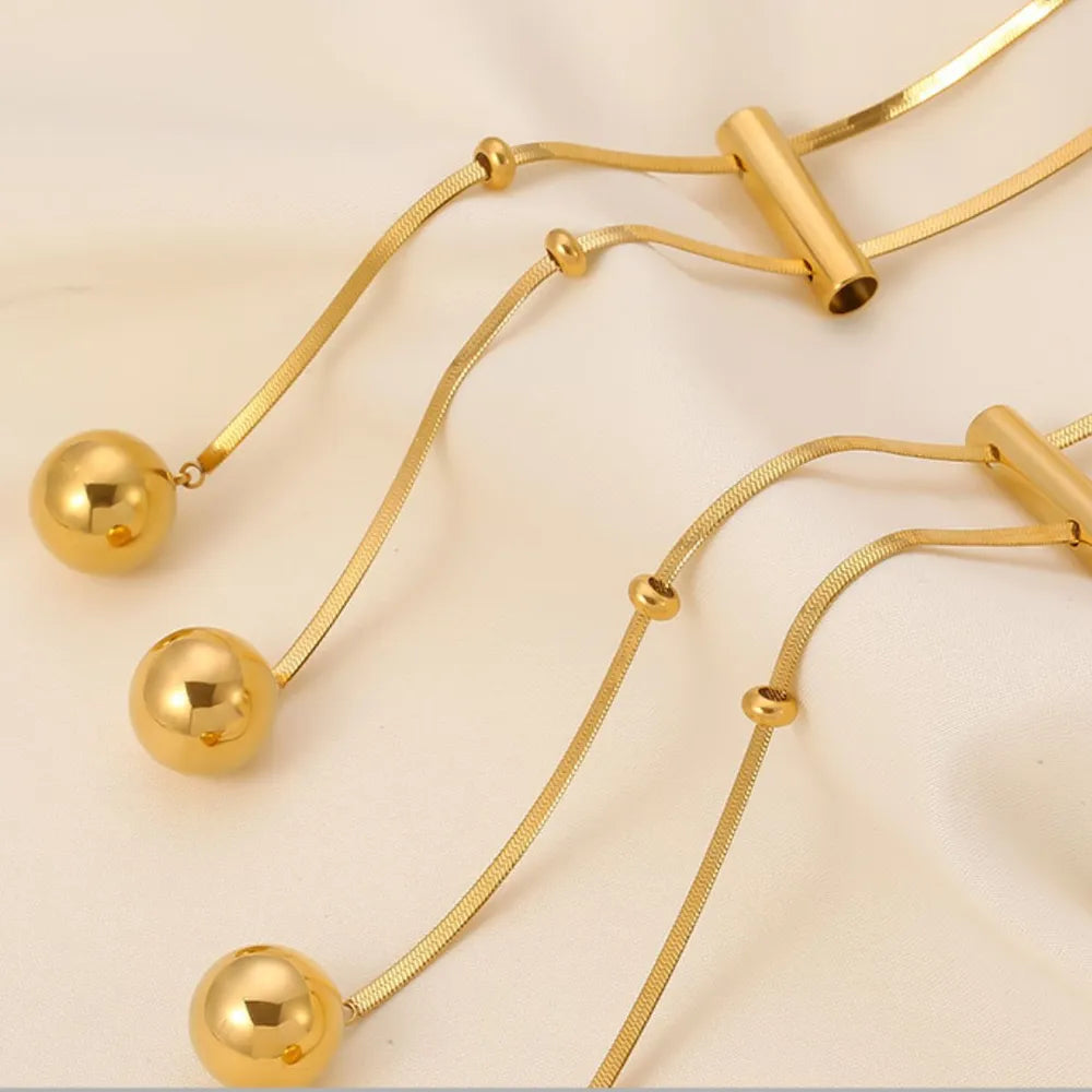 Gold-tone hollow ball charm necklace with metal bar connector