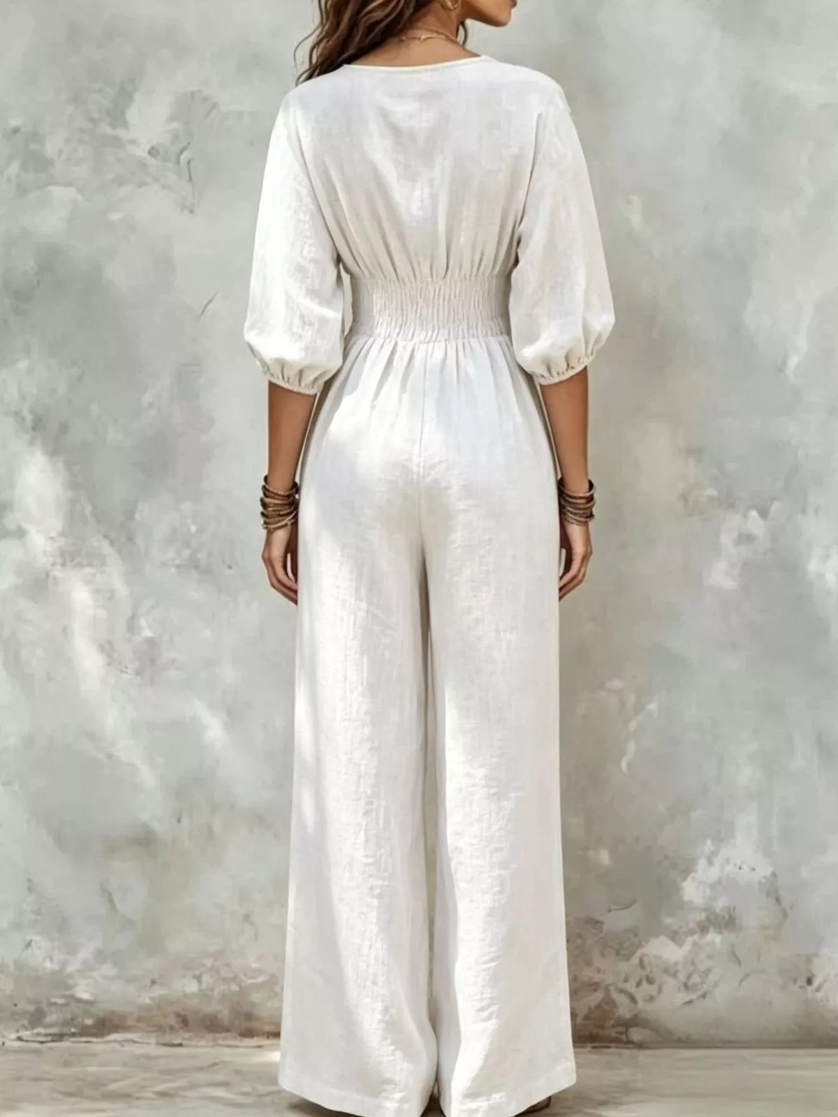 White wide-leg jumpsuit with smocked waist and gathered puff sleeves
