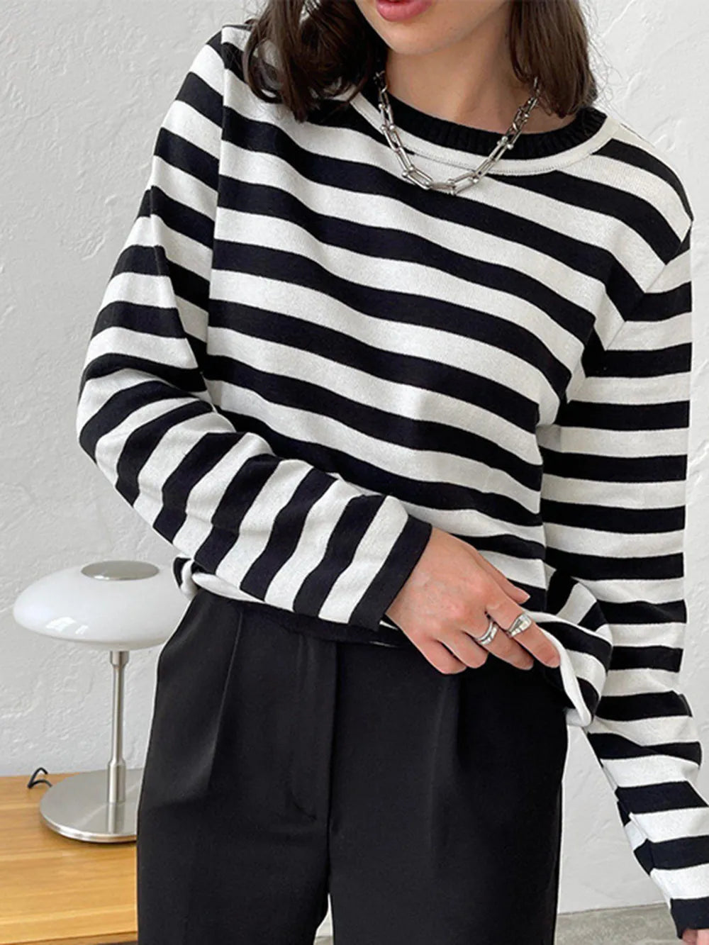 Striped long-sleeve sweater with round neck, black and white horizontal stripes.