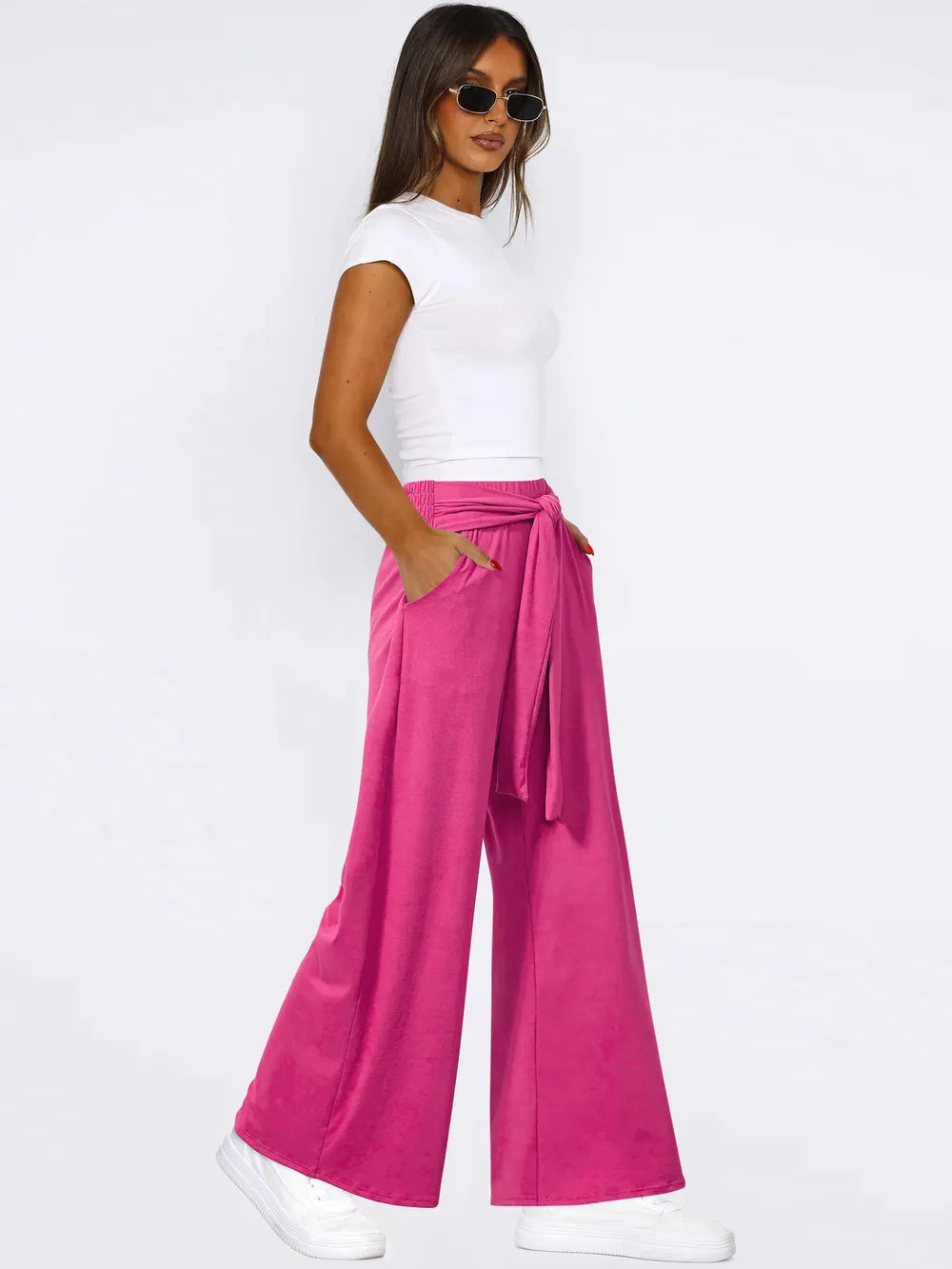 Hot pink wide-leg pants with tied waist and side pockets, loose wide silhouette.
