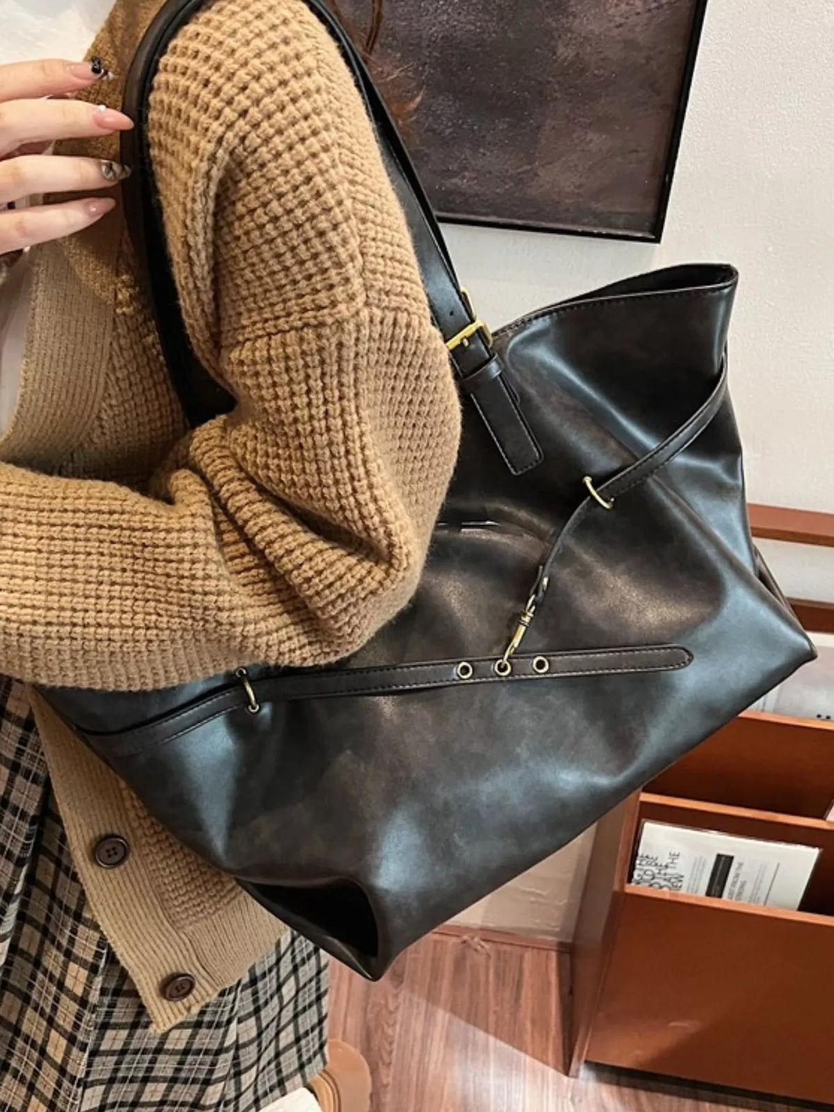 Large vegan leather tote bag, black, side detail with adjustable strap and gold hardware
