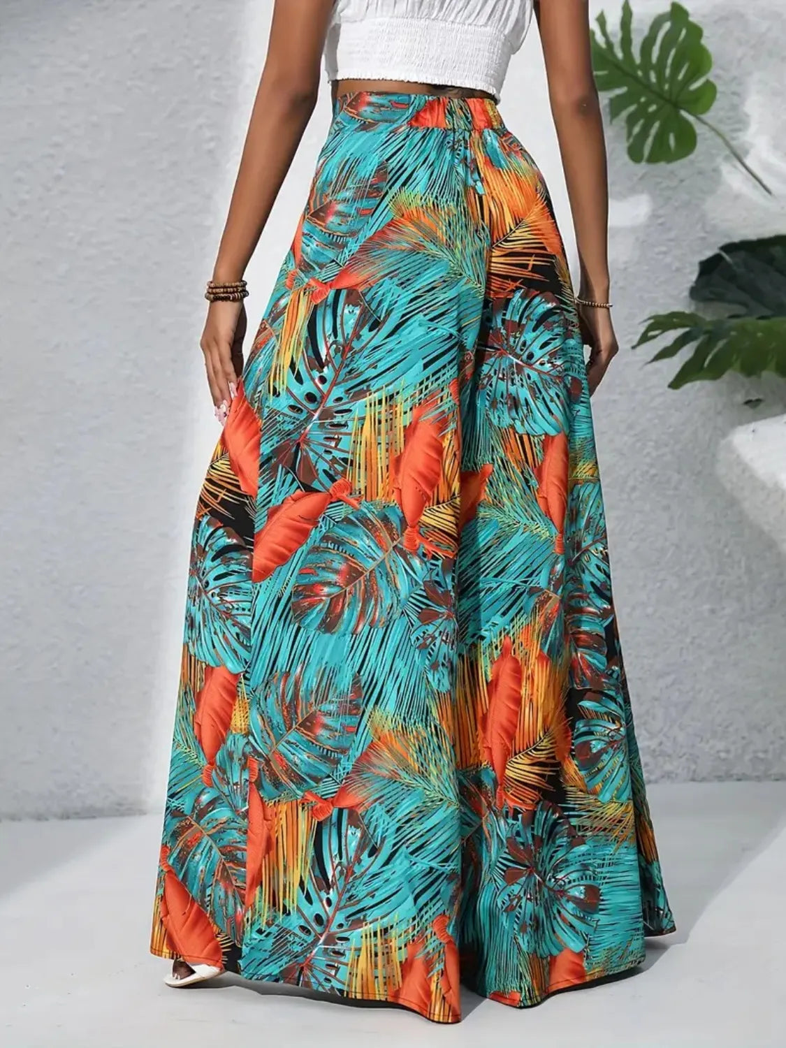 High-waist wide-leg pants with vibrant teal, orange, and black tropical leaf print