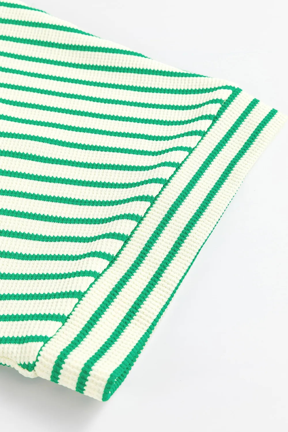 Green-and-white striped romper leg opening with ribbed cuff