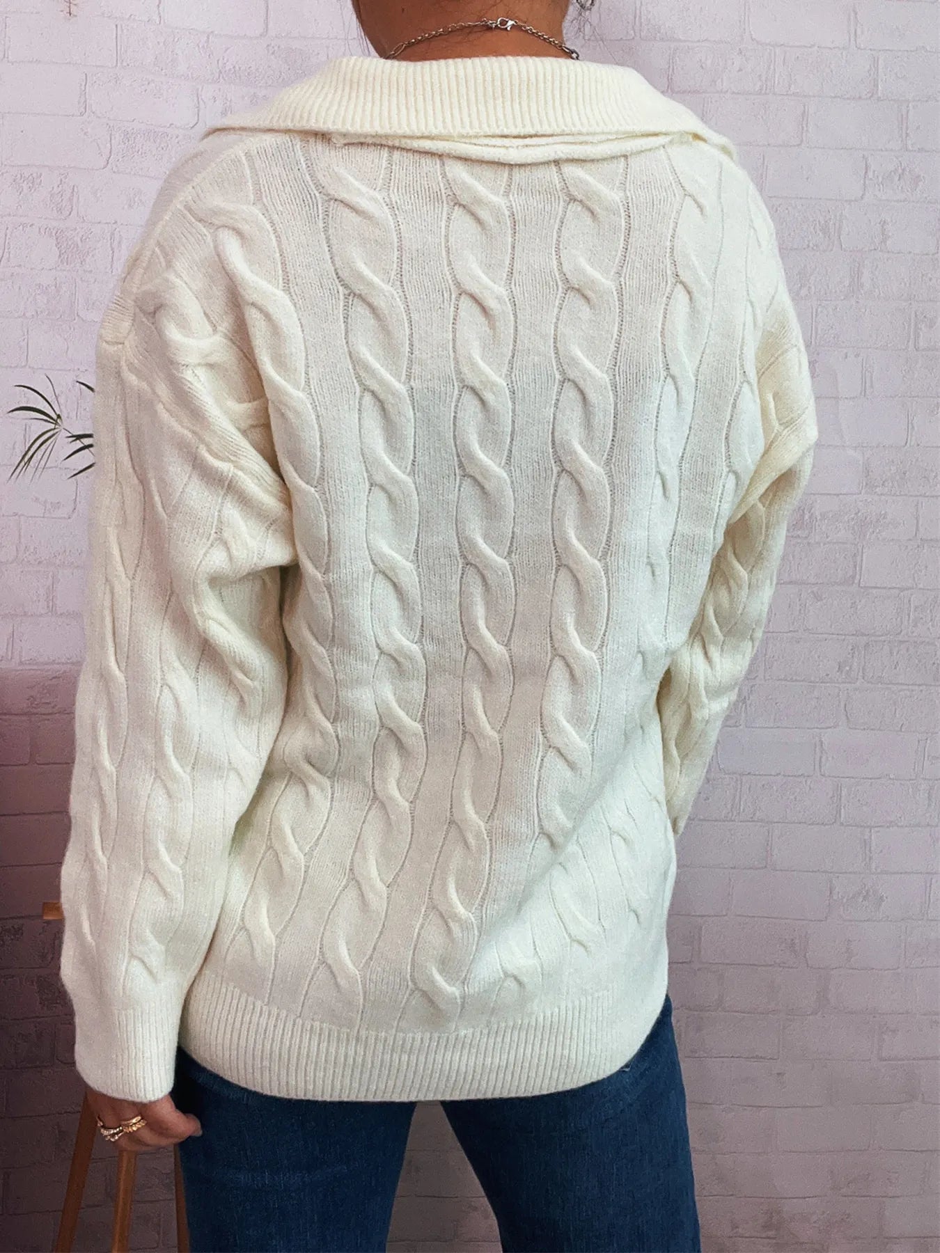 Cream cable knit sweater with raised cable back pattern and ribbed collar and hem