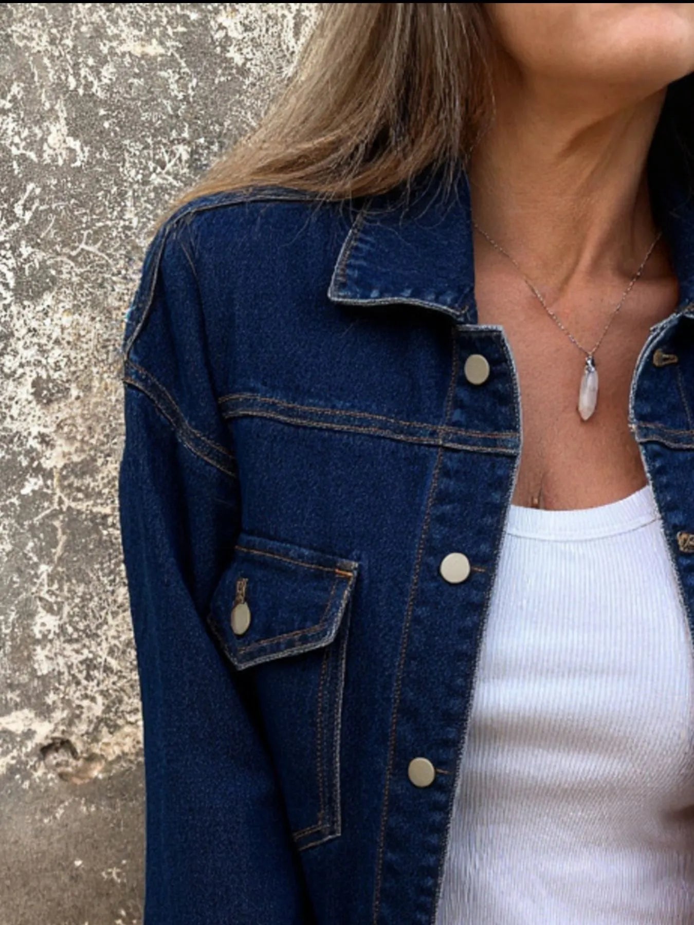 Blue denim jacket side view with button front, chest pocket, and long sleeves