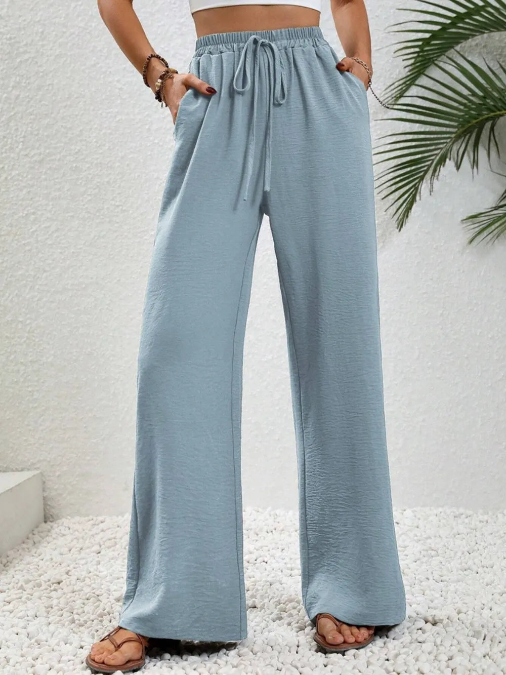 Light blue wide-leg drawstring pants with elastic waistband and relaxed wide legs