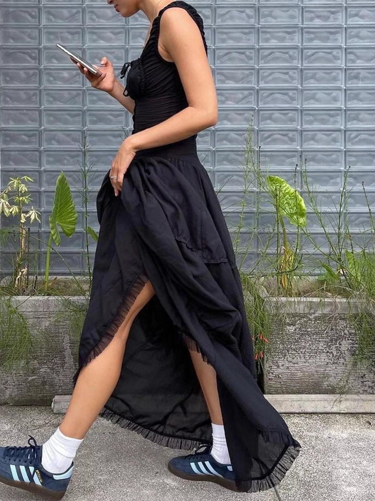 Black tiered maxi dress with square neckline and front slit detail on the layered skirt