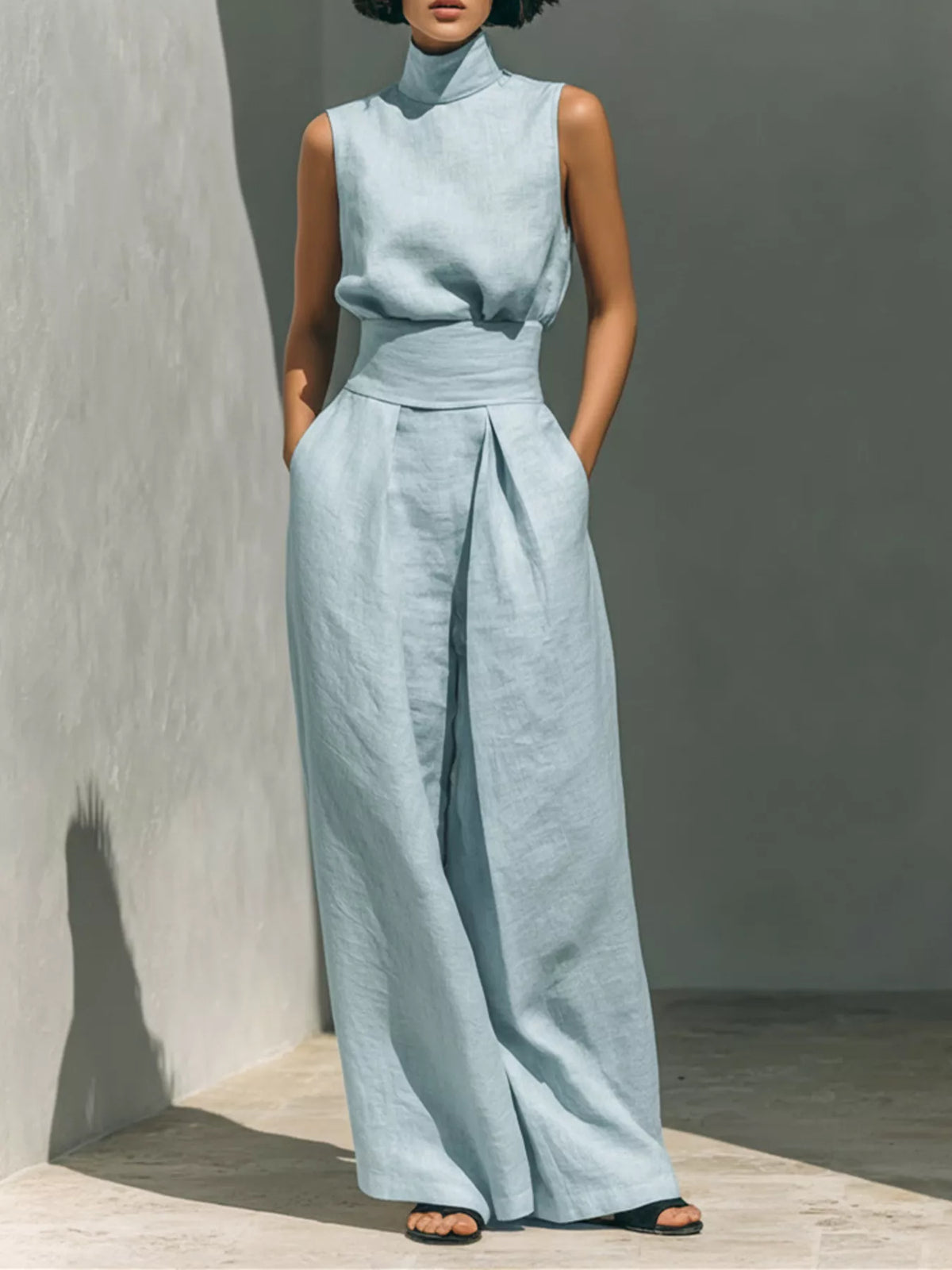 Light blue sleeveless wide-leg jumpsuit with smocked waist and front twist knot