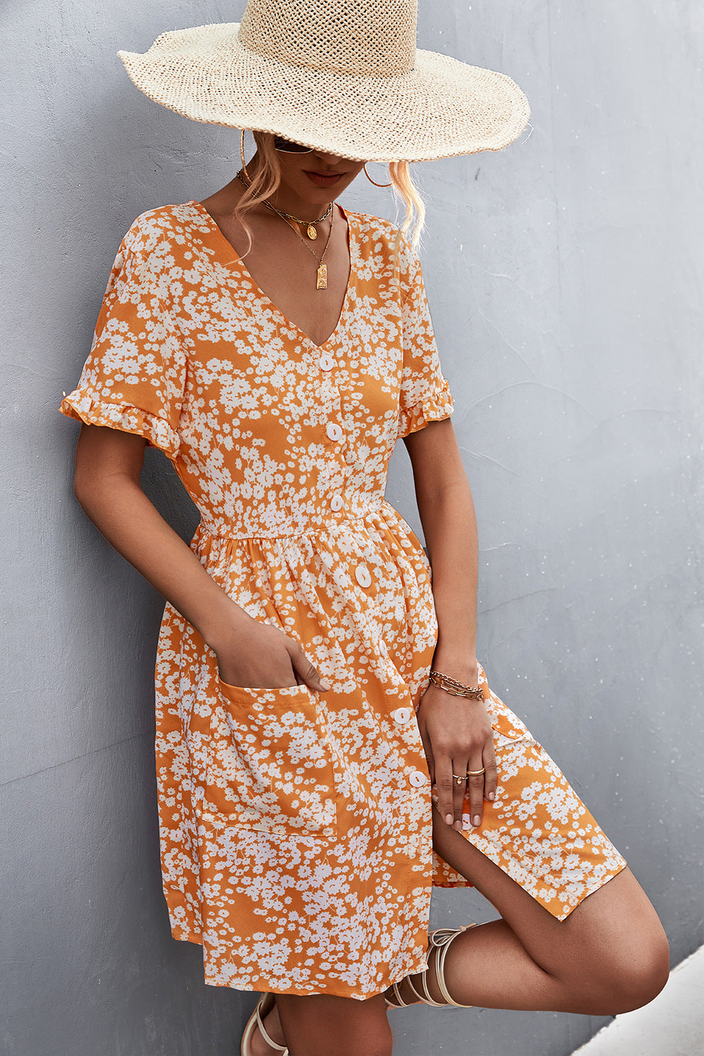 Orange floral button-front dress with V-neck, short sleeves, and patch pockets.