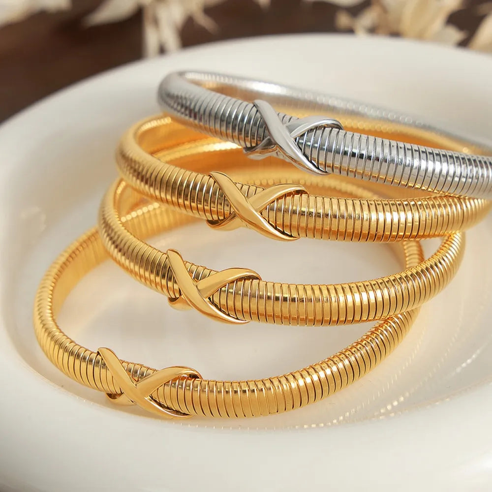 Gold and silver spring coil bracelet with twisted knot clasp, stacked