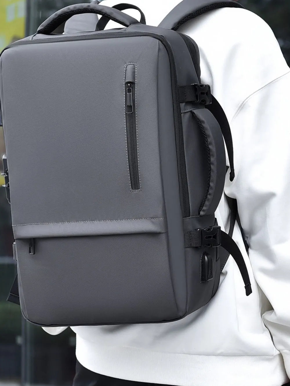 Dark gray backpack with top handle, front zipper pocket, and adjustable straps