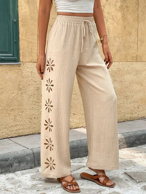 Light beige wide-leg pants with drawstring waist and flower appliques down the side