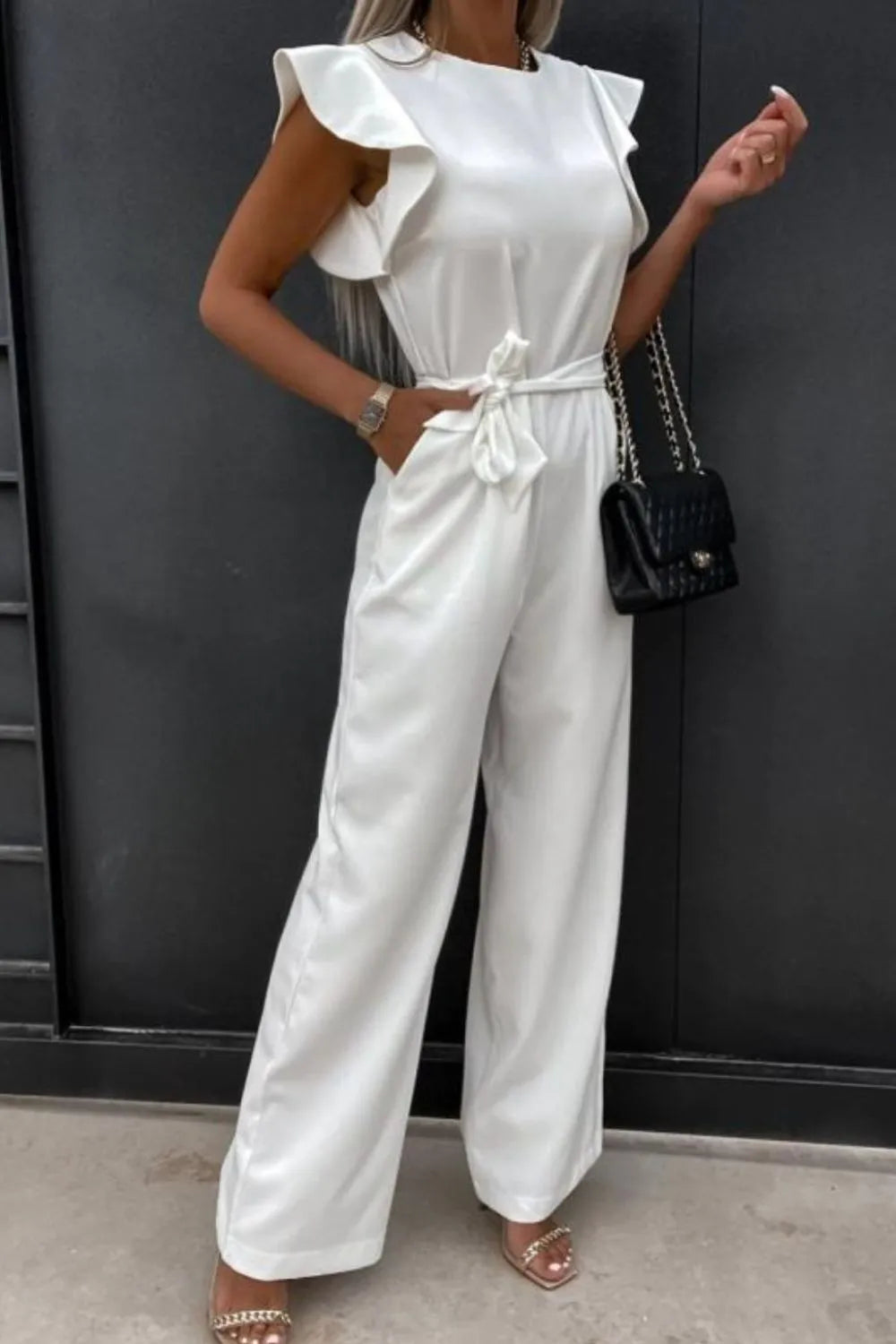 White round-neck cap-sleeve jumpsuit with bow-tie waist and wide pant legs