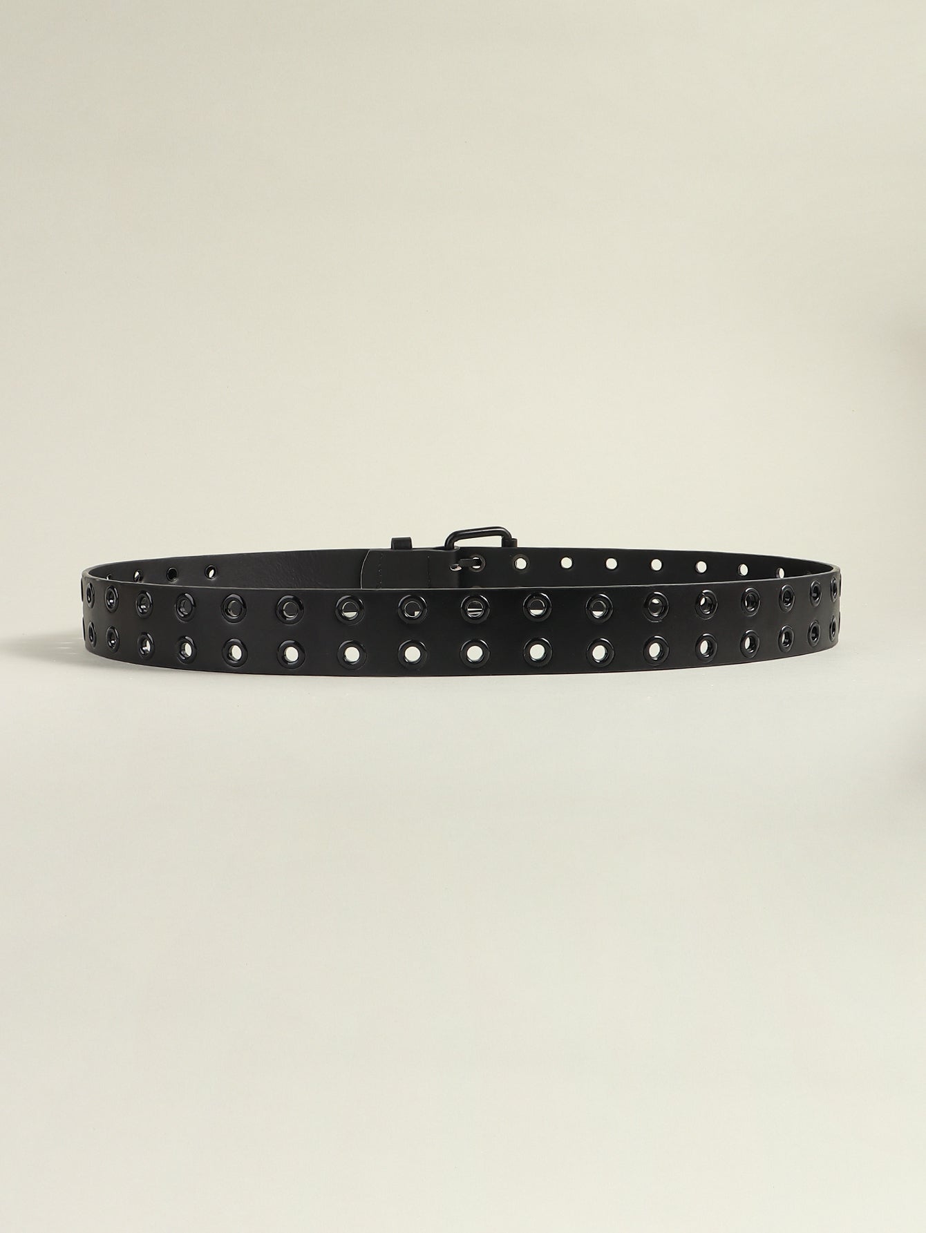 Black vegan leather grommet belt with evenly spaced eyelet studs, side view