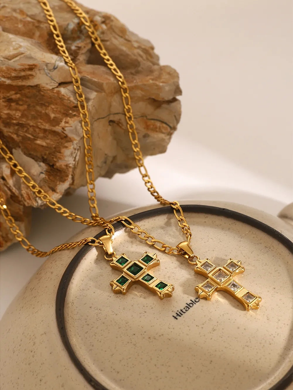 Gold-tone cross pendant necklace with green square stones on a chain